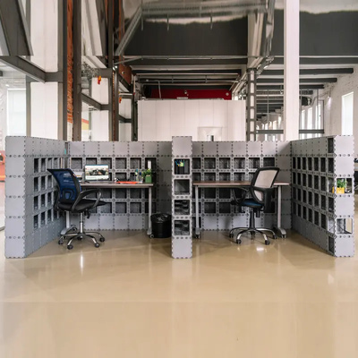 Two Cubik workstations sharing a partition wall, with desks and chairs