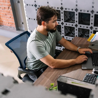 Man working on a laptop at a Cubik office desk